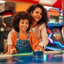 Mother and daughter playing air hockey in an arcade