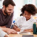 teacher and a private school student practice writing