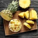 A cut pineapple on a wooden board