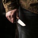 A closeup of a man holding a knife