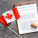 Small Canadian flag next to a visa application document