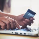 Hands holding credit card and using laptop. Online shopping