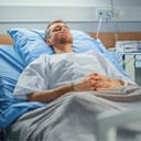 Hospital Ward: Portrait of Handsome Young Man Wearing Nasal Cannula Sleeping in Bed, Fully Recovering after Sickness. Male Patient Dreaming About His Long and Happy Future Life