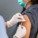 A closeup of a nurse giving a vaccine to a female patient