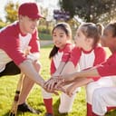 A little league baseball coach saluting with his players