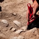 Archaeologist brushing broken items excavated at a site