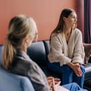 Sad frustrated woman talking in a session with a psychotherapist about her problems.