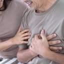 Elderly Asian man with chest pain from a heart attack, His wife was worried when she saw her husband sick, congenital disease, Heart disease, High blood pressure.
