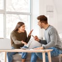 A couple sitting on a couch arguing