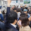 Commuters in Tokyo using the metro during rush hour, crammed train.
