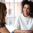 A smiling woman speaking with her manager
