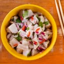 A bowlful of freshly made ceviche with a pair of chopsticks next to it