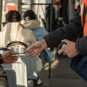 the conductor checks the passenger's ticket in transport. the person shows the ticket to the controller. advertising picture. a tram ride.