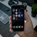 close-up of a person's hand holding a black iPhone 6s