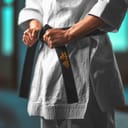 Close-up karate girl tightening black belt - on belt Kaishin wich means "Open Mind"