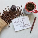 The structure of the caffeine molecule on a paper, with a rustic bag of spilled coffee beans scattered around and a cup of coffee.