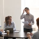 nervous female employee presenting in front of her superiors during at a business meeting