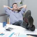 Lazy office worker with his feet lifted on the table