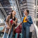 two happy women at the airport excitedly heading to their boarding gate for a trip