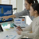 Two women looking at a computer screen displaying data
