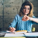 Woman at desk worryingly looking at her wristwatch