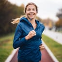 A front facing view of a happy woman running 