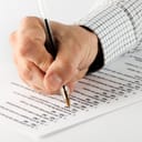 Person filling out a survey sheet with a pen