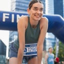 happy female marathon runner at the finish line in the city after finishing the race