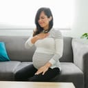 Pretty pregnant woman suffering from acid reflux because of her pregnancy. Caucasian expectant mother touching her chest with a pained expression