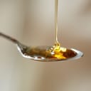 close-up of honey being poured onto a teaspoon