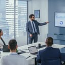 young male businessman presenting results of research on a wall TV displaying data analysis in an office meeting room
