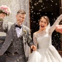 a happy couple on their wedding day being traditionally showered with rice and grain