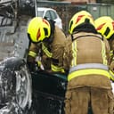 three firefighters using tools to cut car doors and rescue a victim from a terrible car crash accident