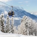 New modern spacious big cabin ski lift gondola against snowcapped forest tree and mountain peaks covered in snow landscape in luxury winter alpine resort. Winter leisure sports, recreation and travel