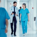 A doctor and a nurse walking down a hospital corridor