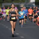 a group of people running a marathon on the street, focus on a happy female contestant with number '1545'
