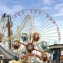 An amusement park with a roller coaster and a ferris wheel
