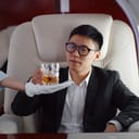A man taking a drink from a flight attendant