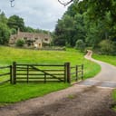 old English country house with a path leading up to it surrounded with greenery