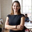 Woman with arms crossed looking at the camera with a smile on her face
