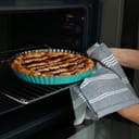 close-up of a woman taking out a delicious homemade cake from the oven