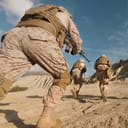 Soldiers in dessert camouflage running in dessert-like area