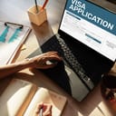 A closeup of a woman applying for a visa using her laptop