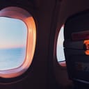 blinds open on an airplane window during sunset