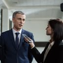 Man in suit giving a statement to a journalist recording on her smartphone