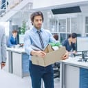 Man leaving his place of work with a box of his belongings