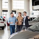 Couple being helped by an agent at a car dealership