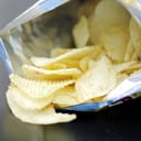 open bag of potato chips on a black table