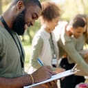 close-up picture of a group of joyful young volunteers during a charity event in an outdoor park