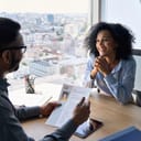 businessman interviewing a female job applicant in a modern office, reviewing her CV for an open position